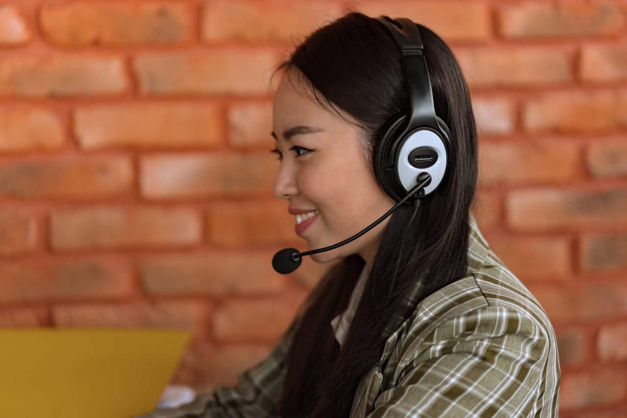 Crafting Captivating Headlines: Your awesome post title goes here Side view of an Asian woman wearing a headset working in an indoor office environment.